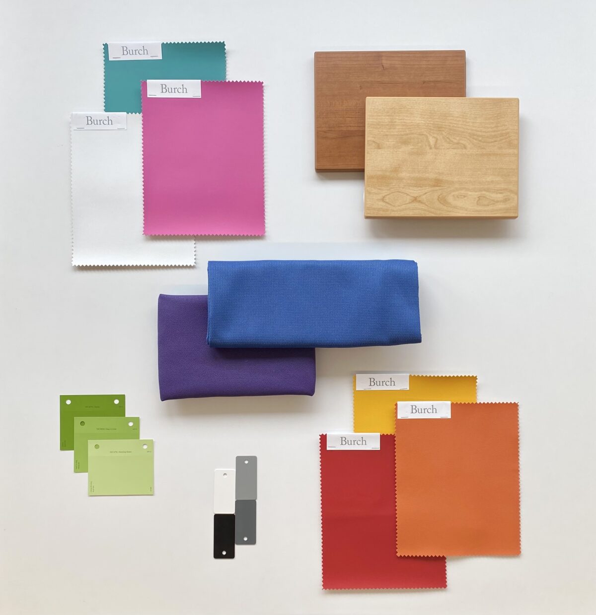 Assorted color and texture swatches on a white background, including wood, fabric, and paint samples in green, purple, pink, orange, and blue tones.