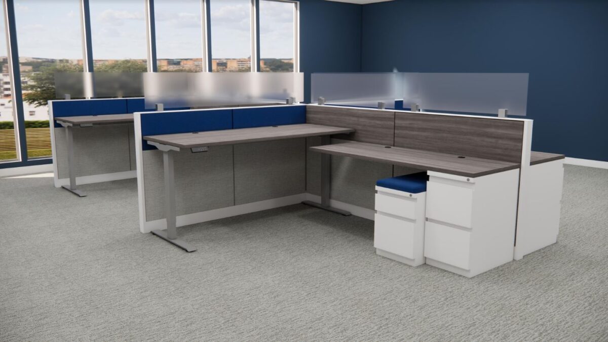 Modern office cubicle with gray and blue walls, featuring large windows. Includes a wooden L-shaped desk, blue partitions, and white storage drawers.