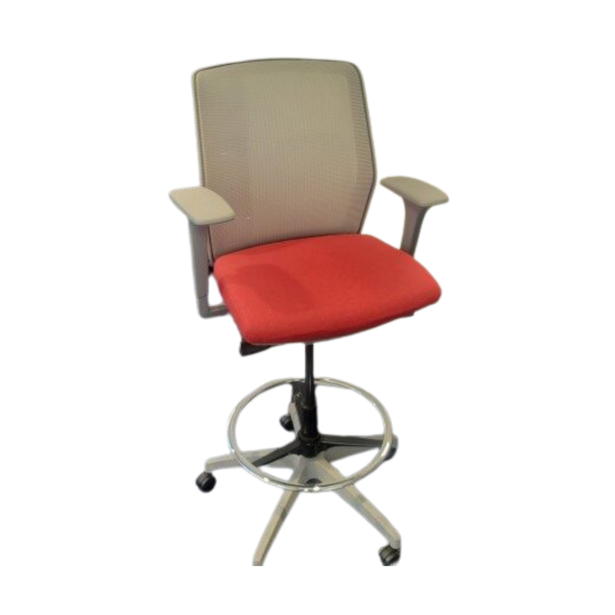 Office chair with red cushioned seat, gray mesh backrest, and armrests. It features a metal foot ring and five caster wheels, suggesting mobility.