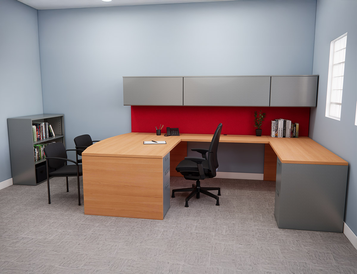 A neatly organized office features a light wood U-shaped desk with gray drawer units, a black chair, and a red accent wall. Books and a plant add decor.