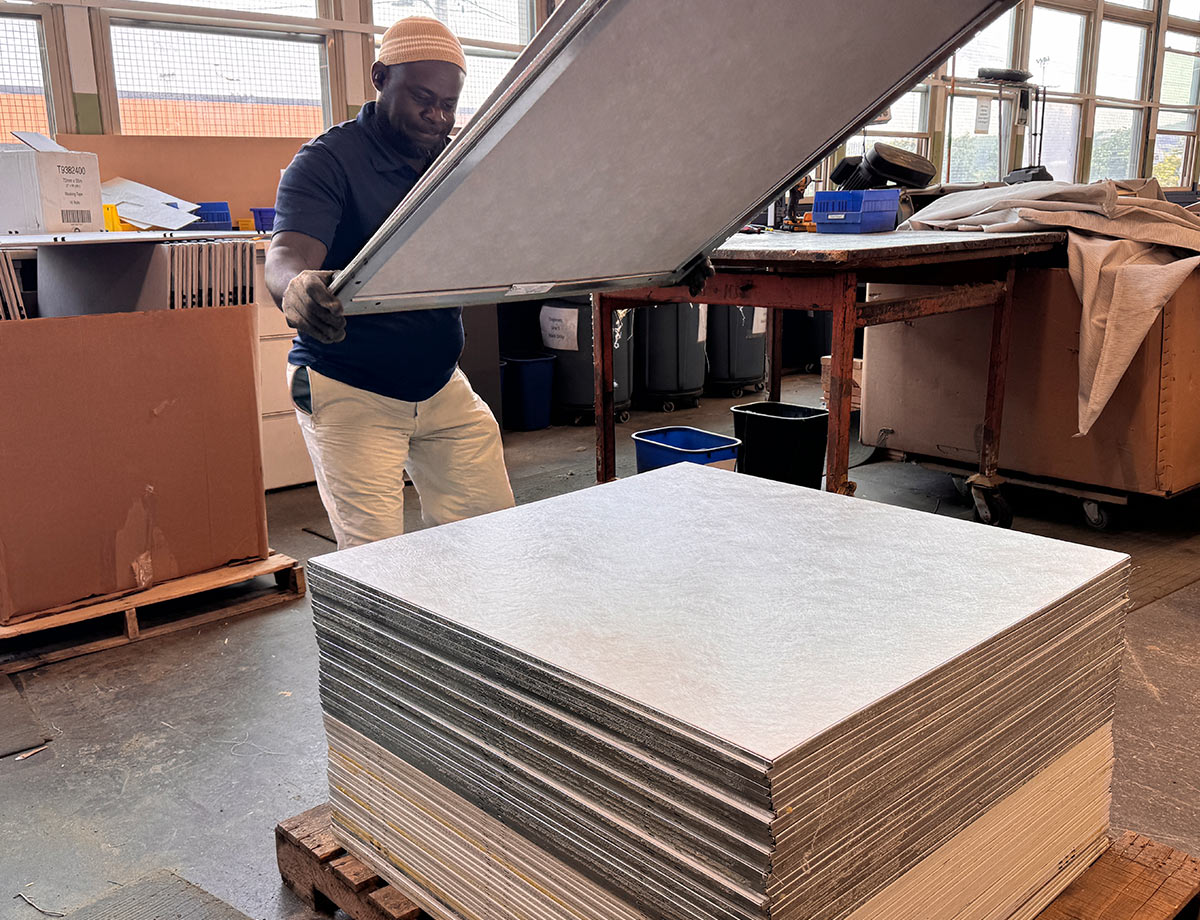 Other in page worker placing finished panel on stack of finished remanufactured panels for workstations 1200w x X