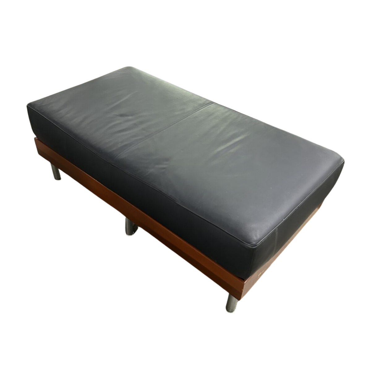 Black leather ottoman with a sleek design, featuring metal legs and a wooden base. The cushion appears smooth and slightly glossy.
