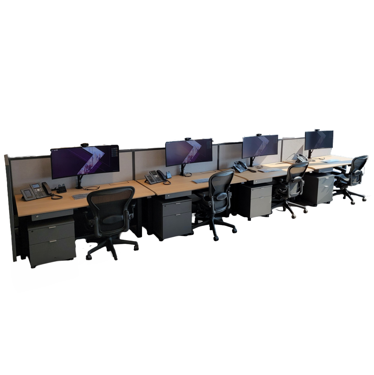 Modern linear benching workstation setup with multiple computer monitors, shared desk surface, and rolling office chairs for collaborative workspace environments.