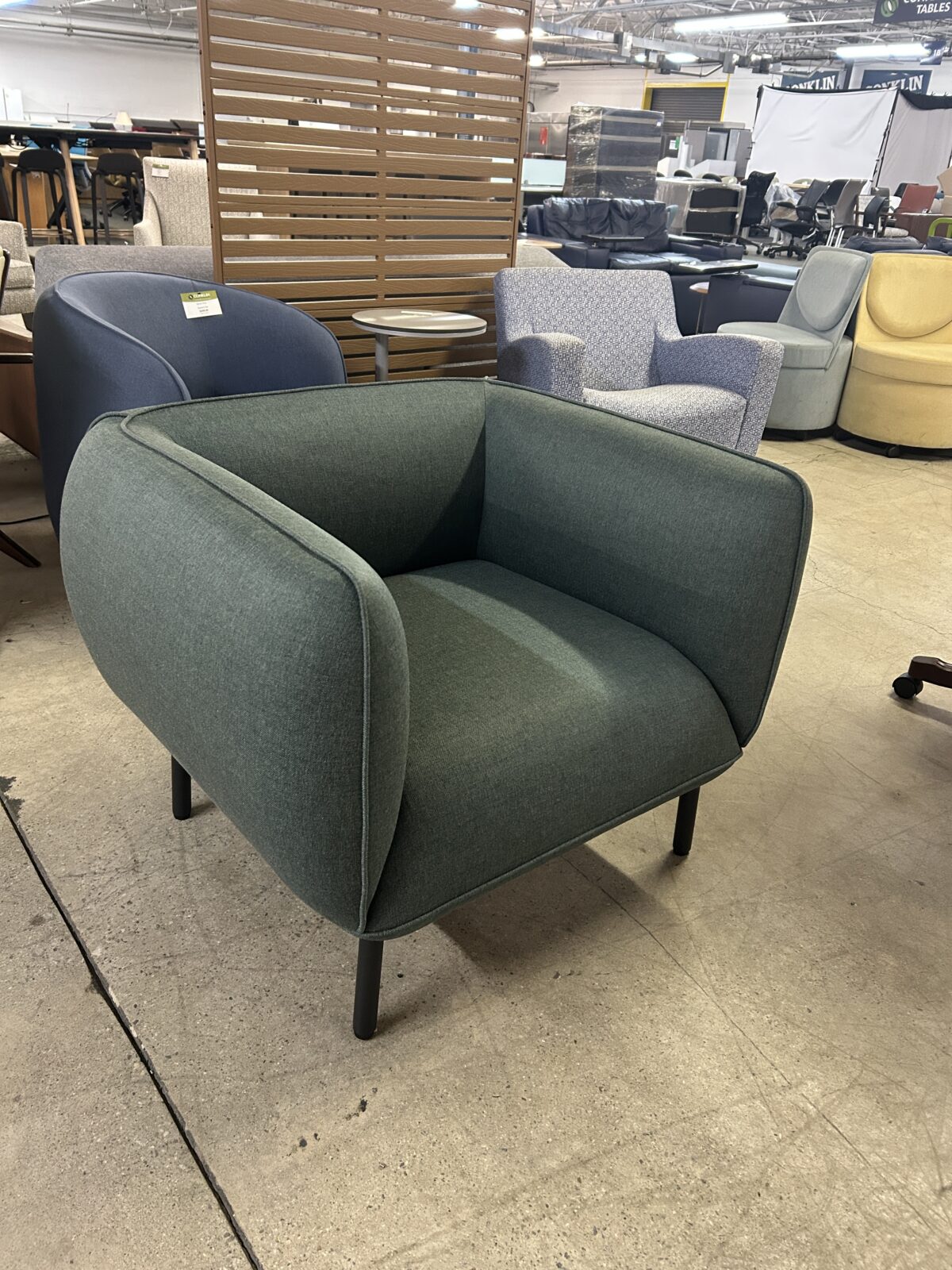 Used lounge chair with green upholstered seat and black metal legs modern accent seating for reception or office lounge areas at Conklin Office Furniture