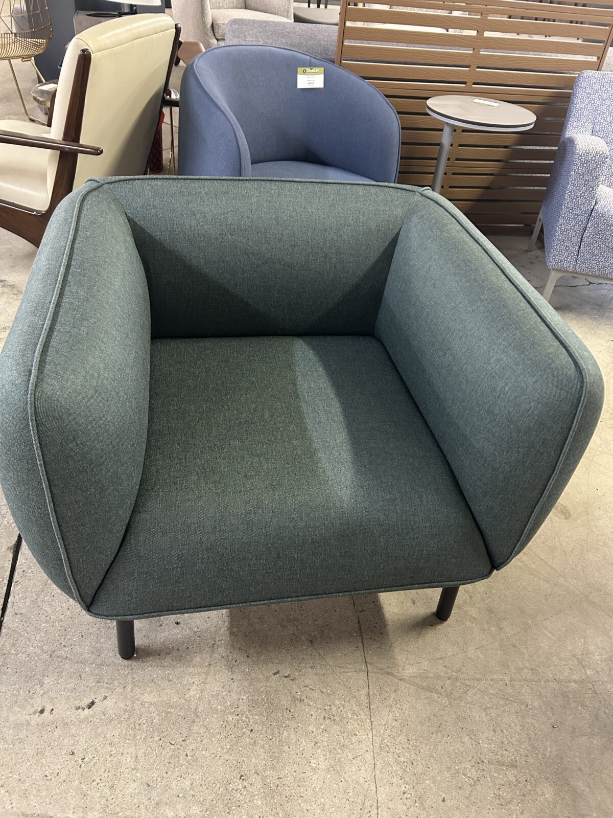 Used lounge chair with green upholstered seat and black metal legs modern accent seating for reception or office lounge areas at Conklin Office Furniture